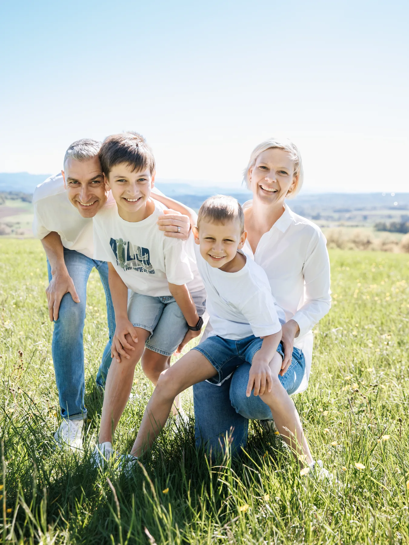 Familienshooting am Hochrhein, eine Familie mit zwei Kindern lacht gemeinsam in der Wiese, Aufnahme von aLx-design