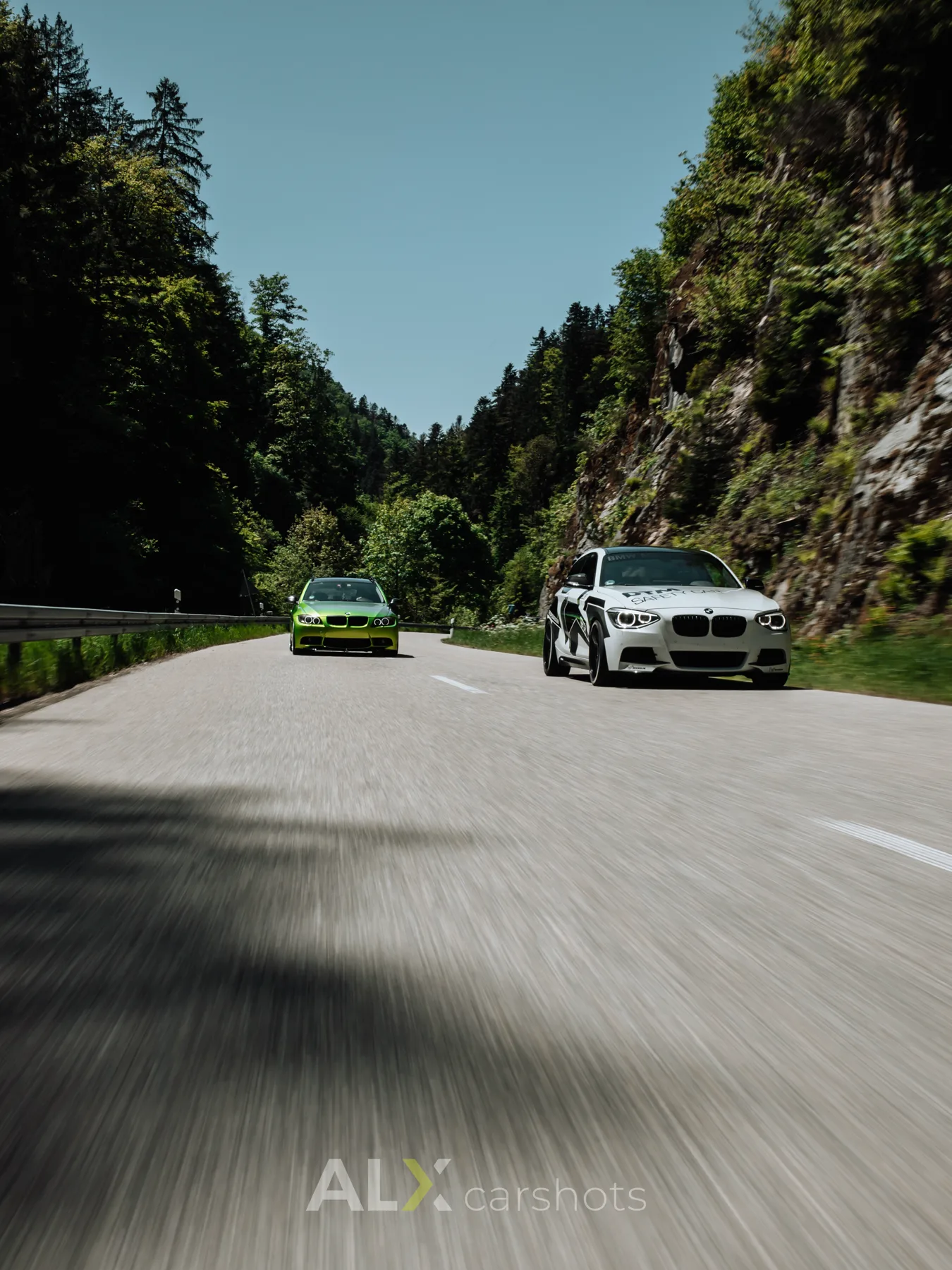 Grüner und weißer BMW als Rollingshot auf einer Schwarzwaldstraße, Automotive-Aufnahme von aLx-design